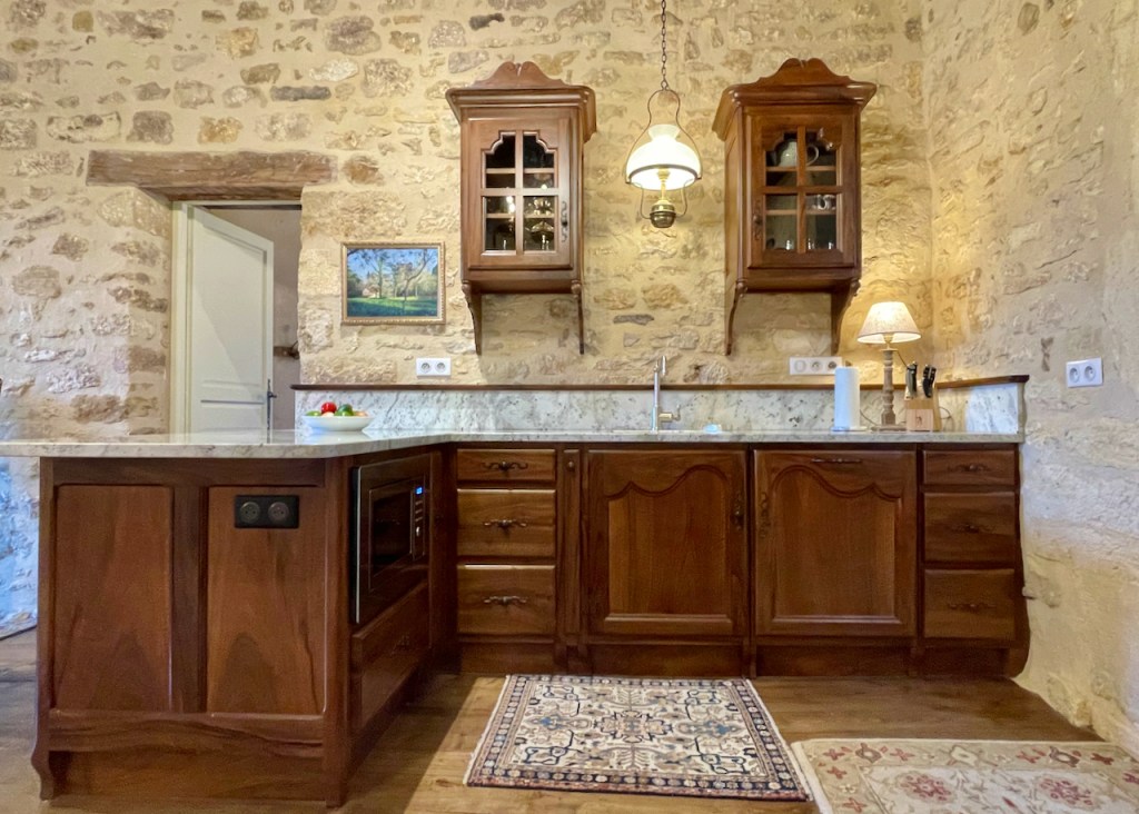 Maison Delluc- Kitchen with granite countertops and artisan-crafted walnut cabinets